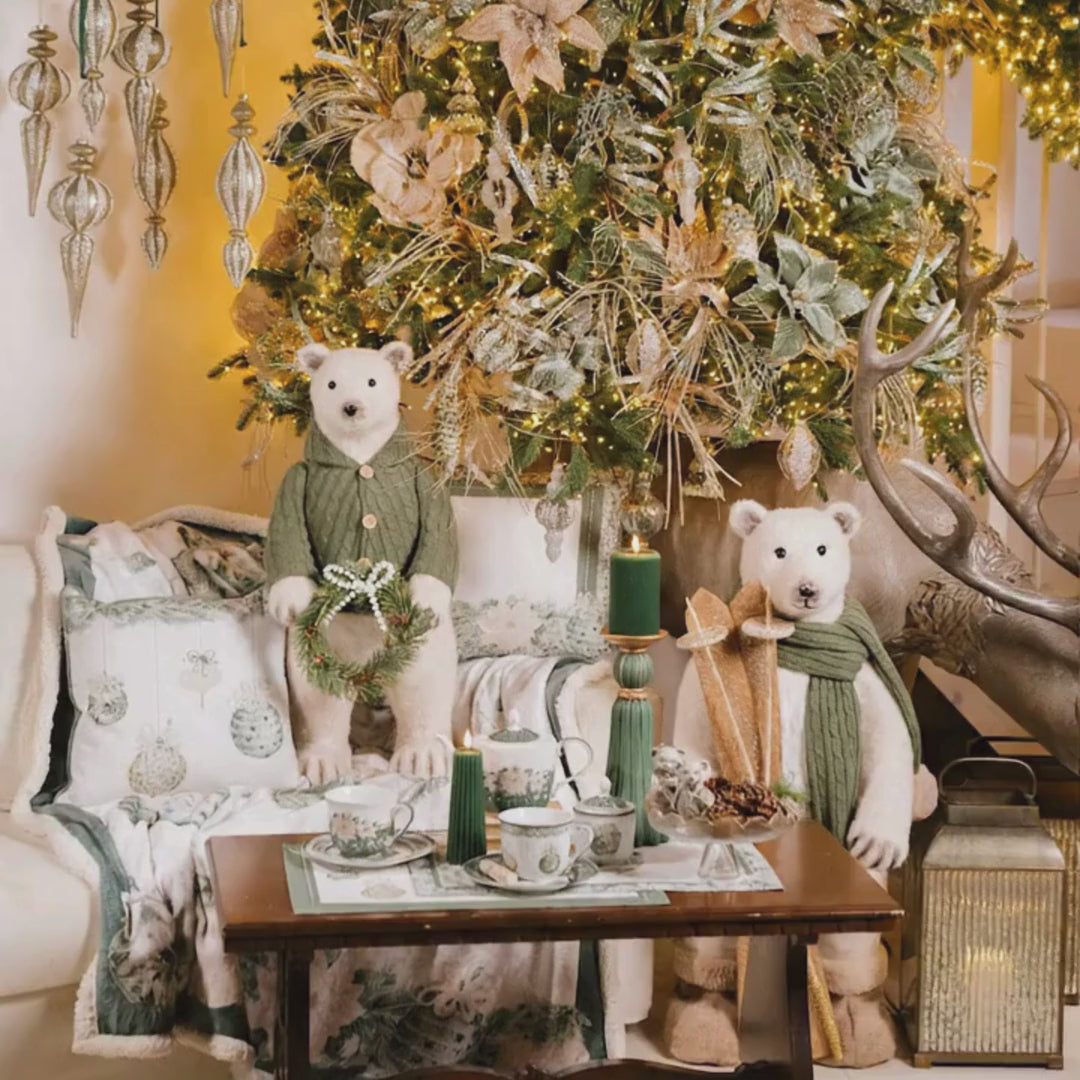 Maxi decorazione natalizia da terra a forma di orso polare in piedi in peluche bianco, con cappotto in maglia treccia verde bosco e bottoni in legno, mentre regge una ghirlanda con fiocco di perle, altezza 73 cm, Nuvole di Stoffa, Tutto Chic.