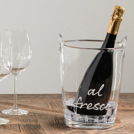 Secchiello rinfrescatore portabottiglia realizzato in vetro soffiato e decorato con la scritta "al fresco. Dimensioni: altezza 26 cm e diametro 19.5 cm. In negozio e online su tuttochic.it