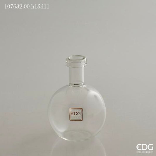 Vaso ampolla a forma di bottiglia in vetro trasparente. Ideale come vaso monofiore o ampolla per profumi ambiente. Dimensioni: cm ø 11 x h 15 (diametro bocca cm 3). In negozio e online su tuttochic.it