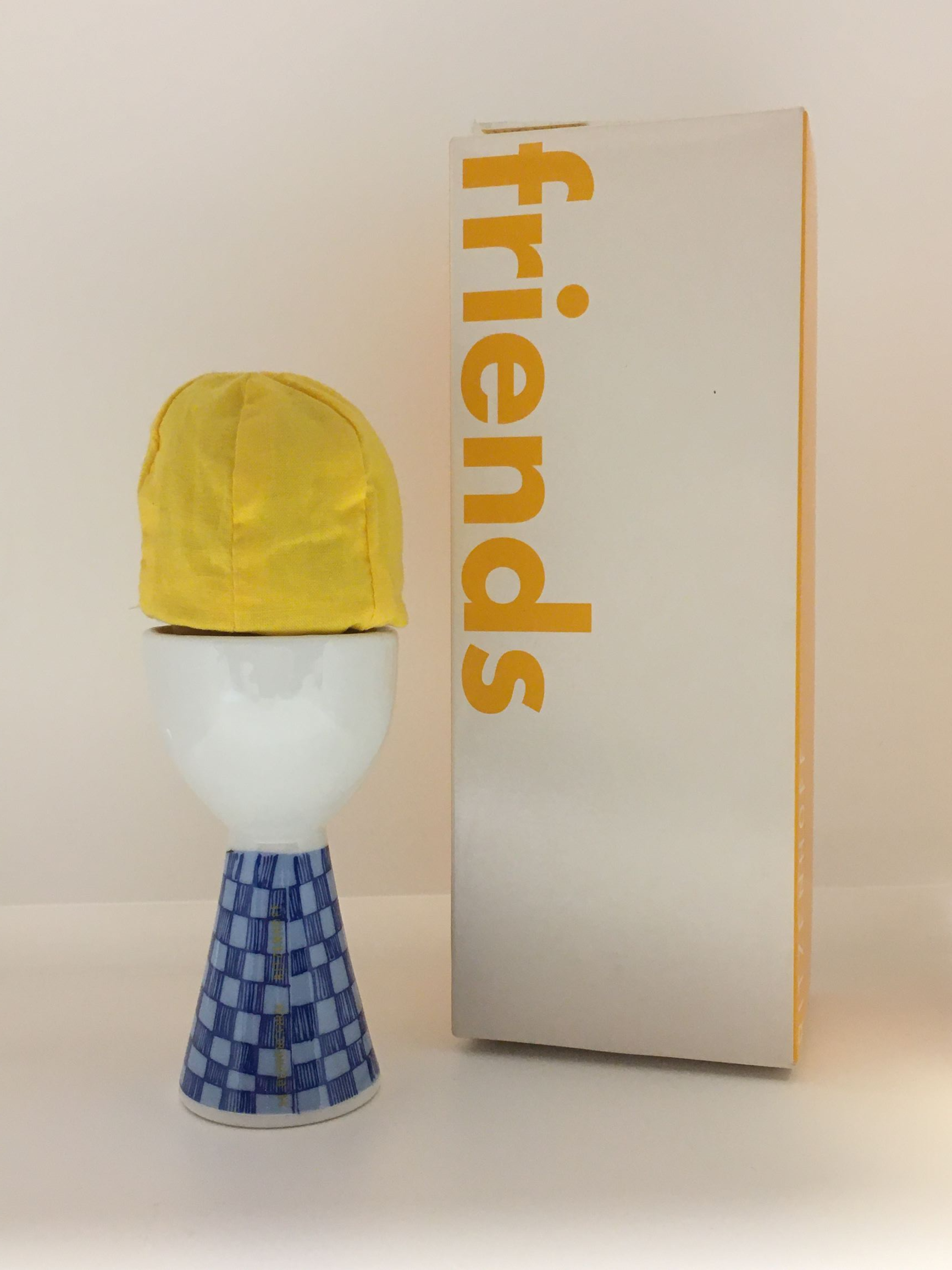 Porta uovo in porcellana con cappello in tessuto, disegnato da Marie Peppercorn nel 2002, Edizione Limitata, della linea "friends" di Ritzenhoff. Dimensioni solo porta uovo: mm 59 x 110 h