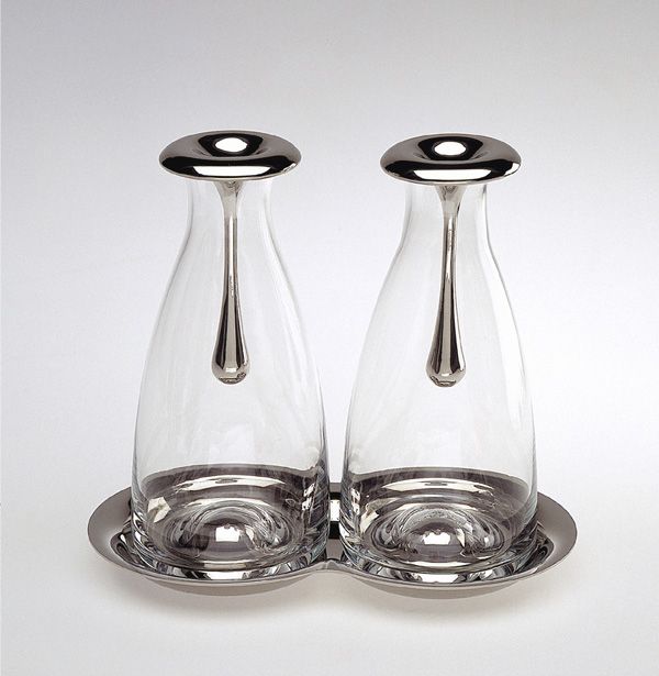 Set olio e aceto in vetro soffiato e acciaio inox dal design particolare. Disegnato da Gijs Bakker gioielliere e designer industriale olandese. I design di Bakker coprono gioielli, accessori per la casa ed elettrodomestici, mobili, interni... Dimensioni: 18 x 10,5 x 16. In negozio e online su tuttochic.it