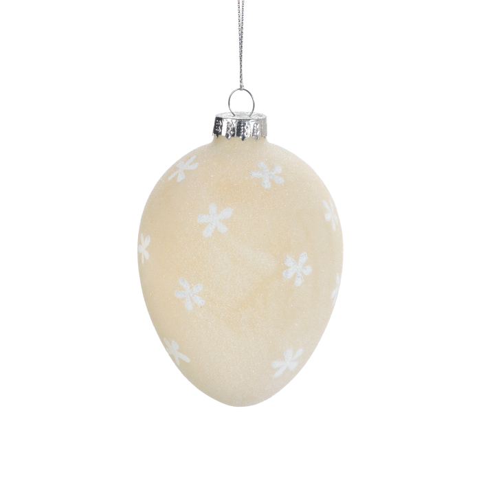 Uovo da appendere in vetro satinato di colore beige decorato con fiorellini bianchi. Dimensioni: Ø 7 x 10,5. In negozio e online su tuttochic.it