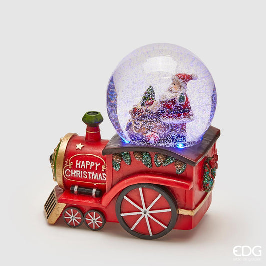 Sferacqua in resina decorata a forma di treno con Babbo Natale, carillon e luci. Il carillon funziona con 3 batterie ministilo. Dimensioni: cm 15 x 10 x 16 h. In negozio e online su tuttochic.it