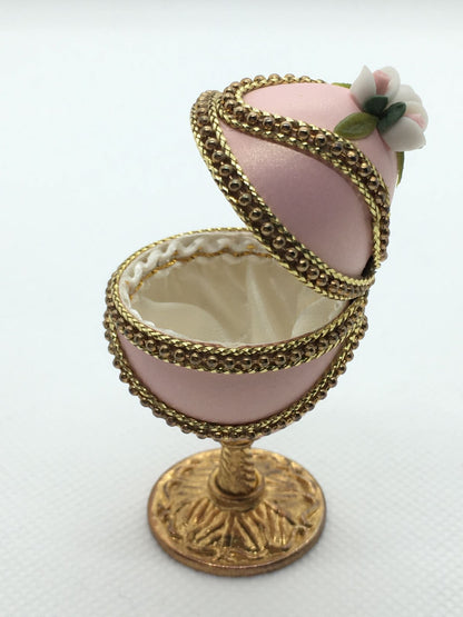 Vero uovo di quaglia lavorato e decorato di colore rosa, apribile porta gioie. Dimensioni: diametro interno cm 3 x 6,5 h