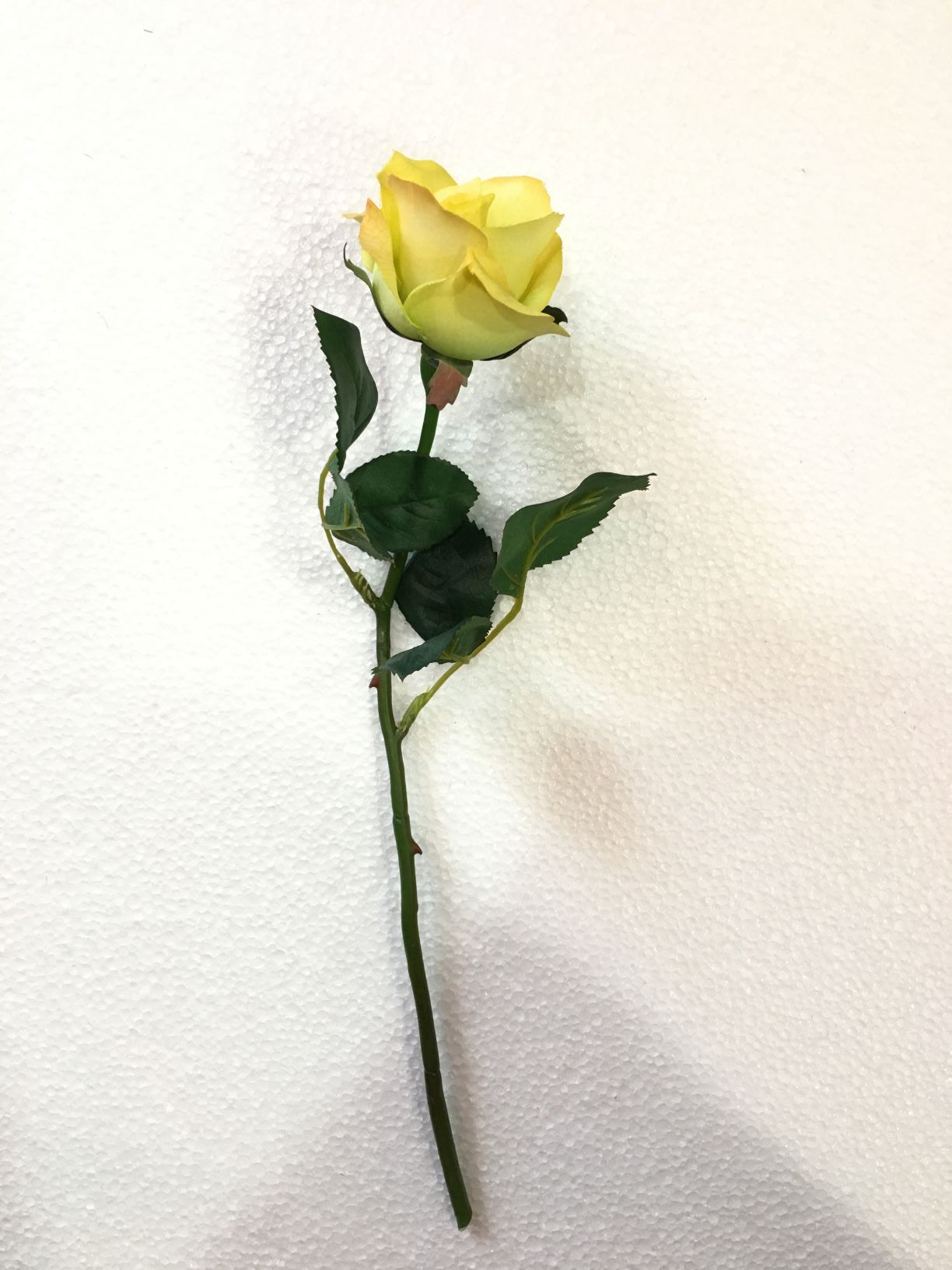 Fiore artificiale mini rosa di colore giallo. Dimensioni: cm 36.