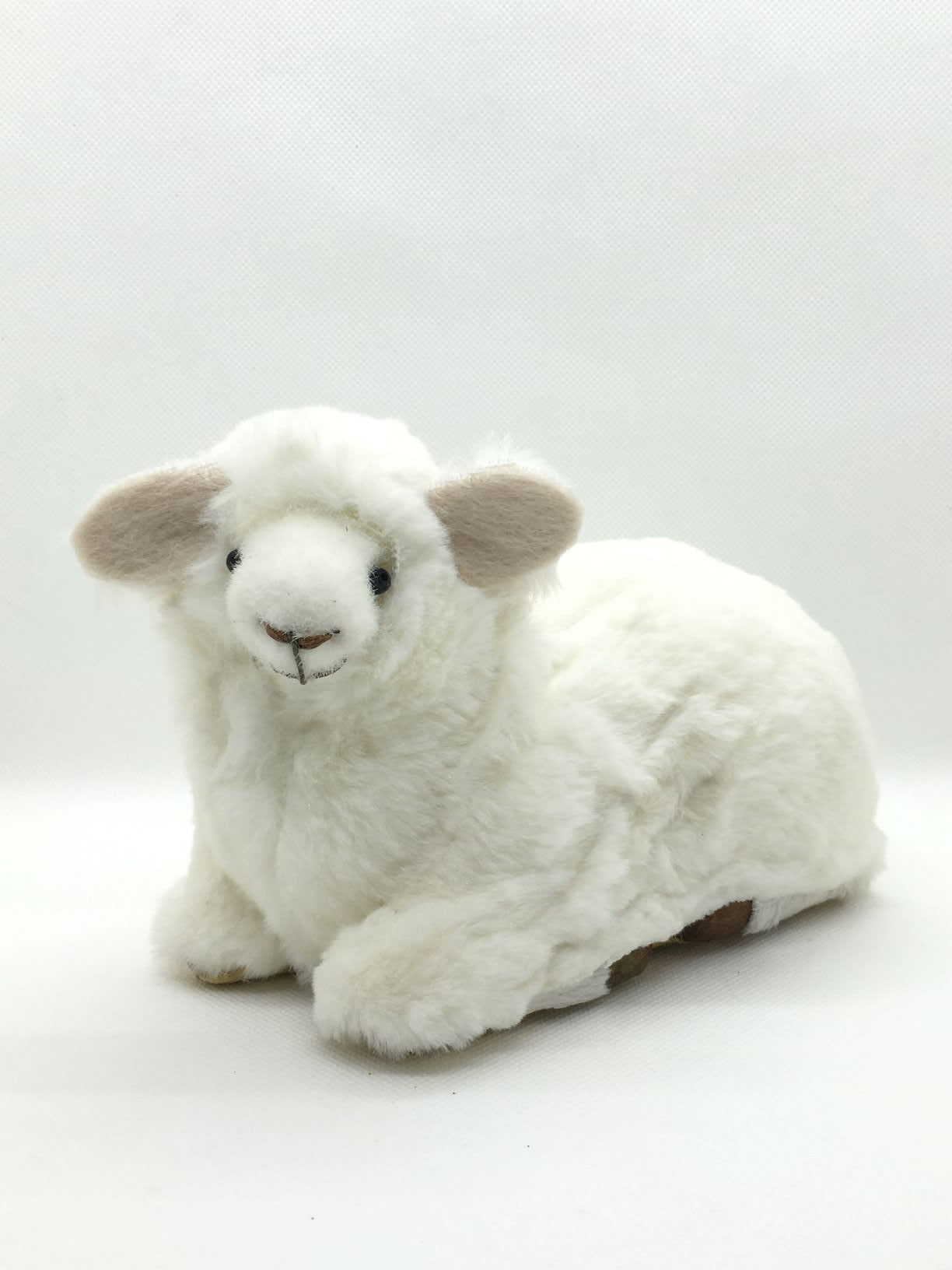 Pecorella seduta di peluche. Dimensioni: cm 18 x 12 h Articolo decorativo, non è un giocattolo.