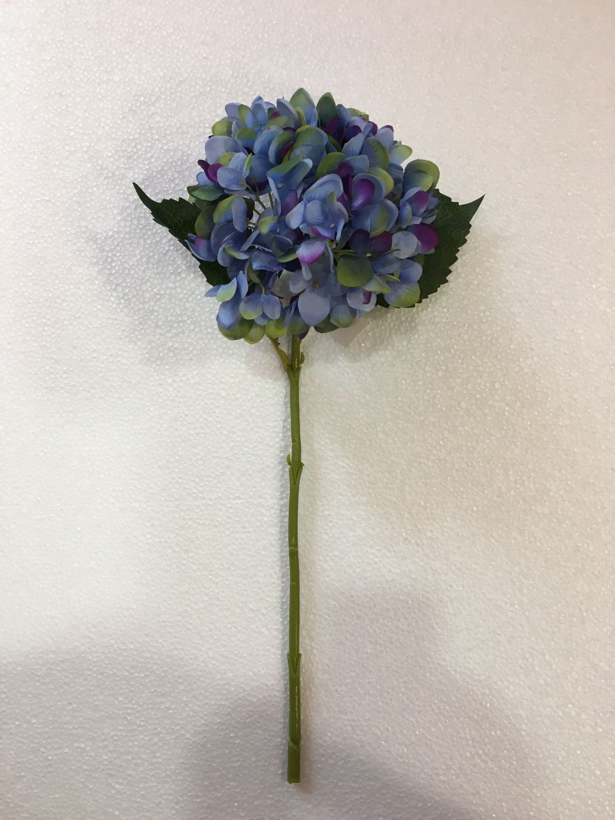 Fiore artificiale di Ortensia di colore azzurro sfumato con 2 foglie. Dimensioni: cm 19 x 46 h Petali in tessuto e ramo in plastica. In negozio e online su tuttochic.it