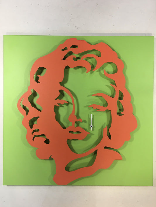 Orologio da parete in metallo di colore verde e rosso pomodoro raffigurante Marilyn Monroe. Dimensioni : cm. 59 x 59 x 6. In negozio e online su tuttochic.it