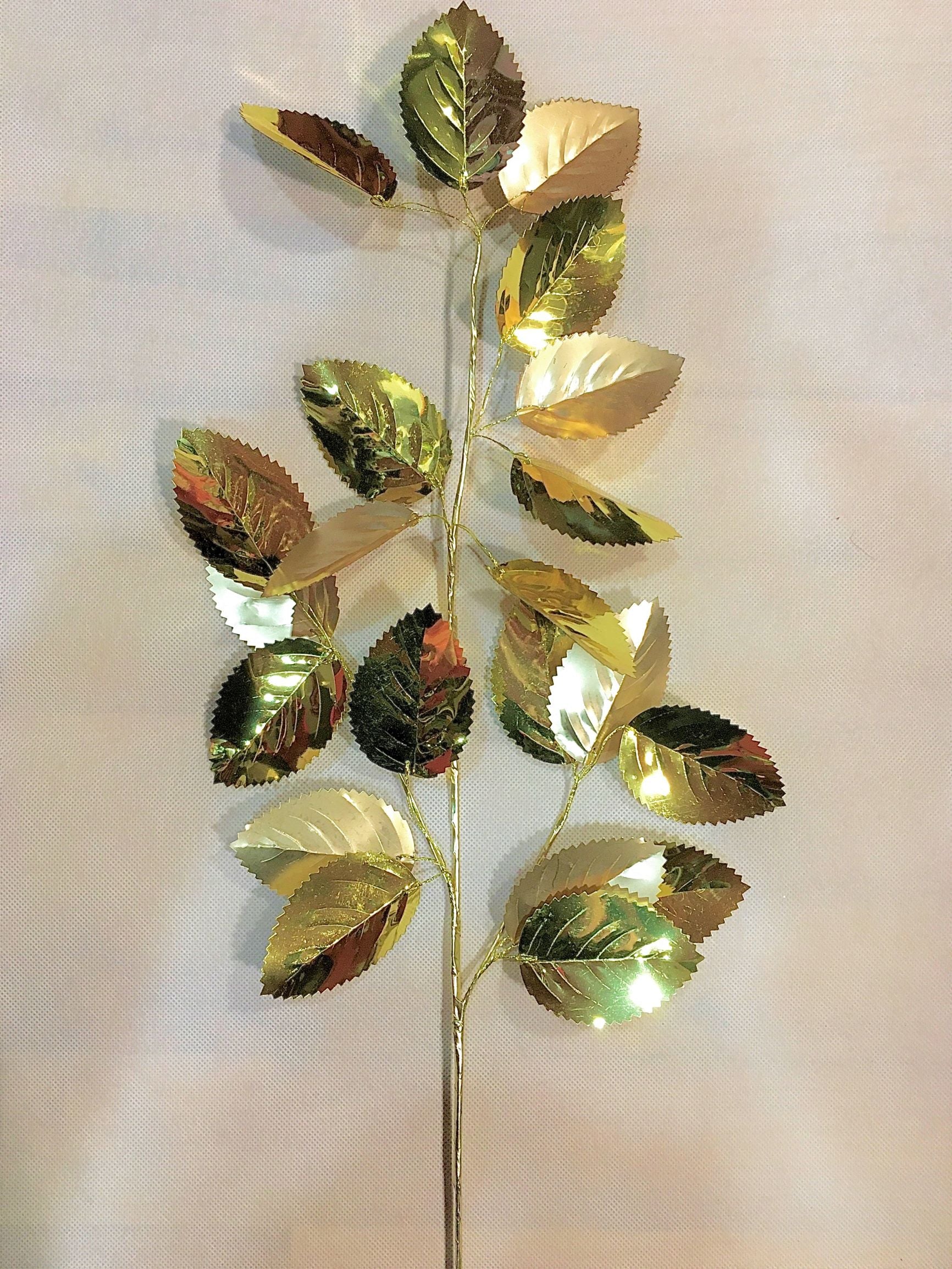 Ramo di foglie dorate effetto metallico. Ideale per arricchire composizioni di fiori artificiali, inserire nell'albero di Natale o soddisfare le tue esigenze decorative. Dimensioni: altezza cm 67